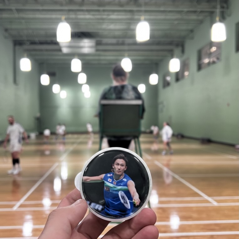 Custom badminton tube cap with player photo design held courtside at Centre Avenue Badminton Calgary